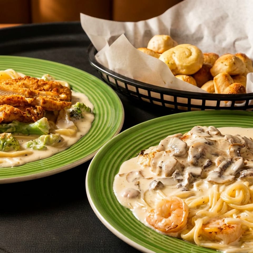 Two creamy pasta dishes: chicken and broccoli, shrimp and mushroom, plus a basket of bread.
